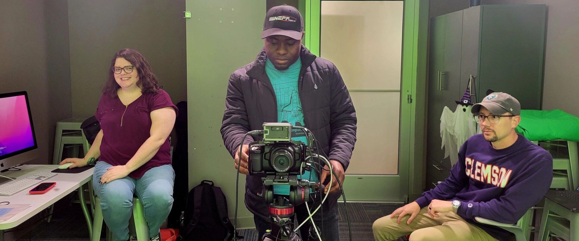 Alumna behind a camera in a classroom